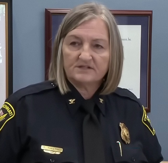 Female Cincinnati police chief in uniform speaking during a press conference related to a single mom incident.