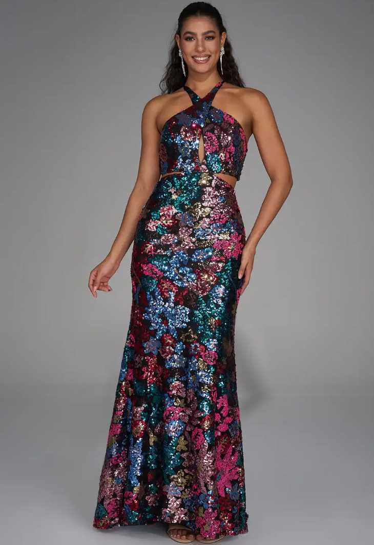 Woman in a colorful, floral sequin gown posing confidently against a gray background.